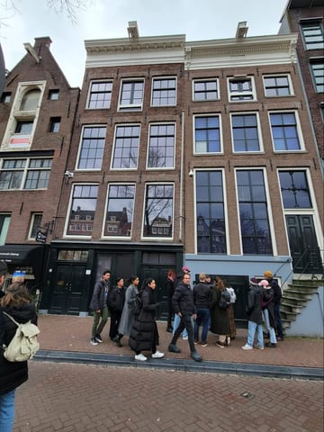 The Anne Frank House on an Amsterdam street, with visitors gathered outside